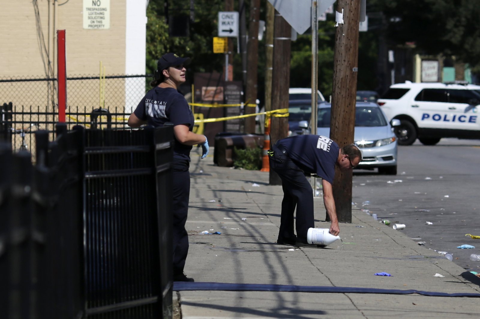 Cincinnati firefighters use bleach to clean and remove pools of blood left at the scene of a mass shooting near Grant Park in the Over-the-Rhine neighborhood of Cincinnati, Ohio, U.S., Aug. 16, 2020. (AP Photo)