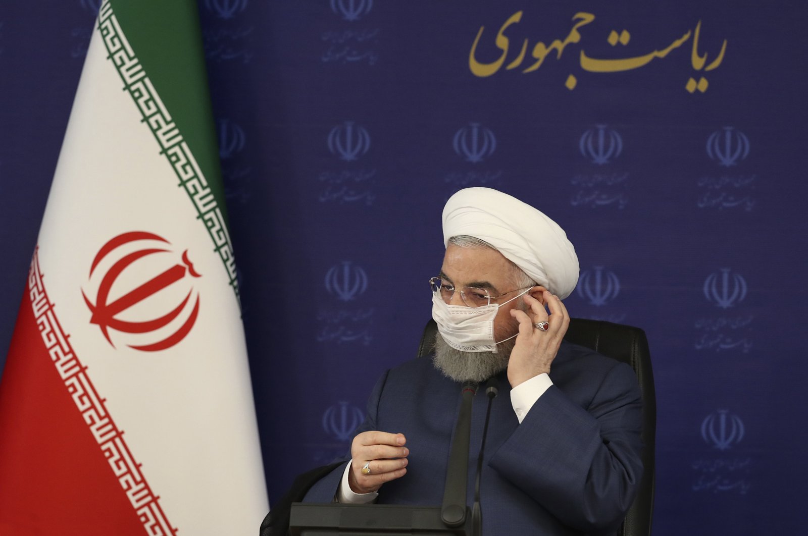 Iranian President Hassan Rouhani adjusts his face mask, Tehran, July 18, 2020. (AP Photo)
