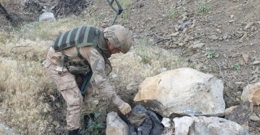 A Turkish soldier inspects items recently seized from the PKK during counterterrorism operations in Turkey’s southeastern Hakkari province, Aug. 18, 2020.
 (AA)