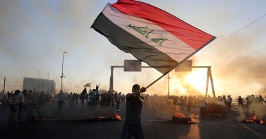 An Iraqi protester waves the national flag during a demonstration against state corruption, failing public services and unemployment in the Iraqi capital Baghdad, Oct. 5, 2019. (AFP Photo)