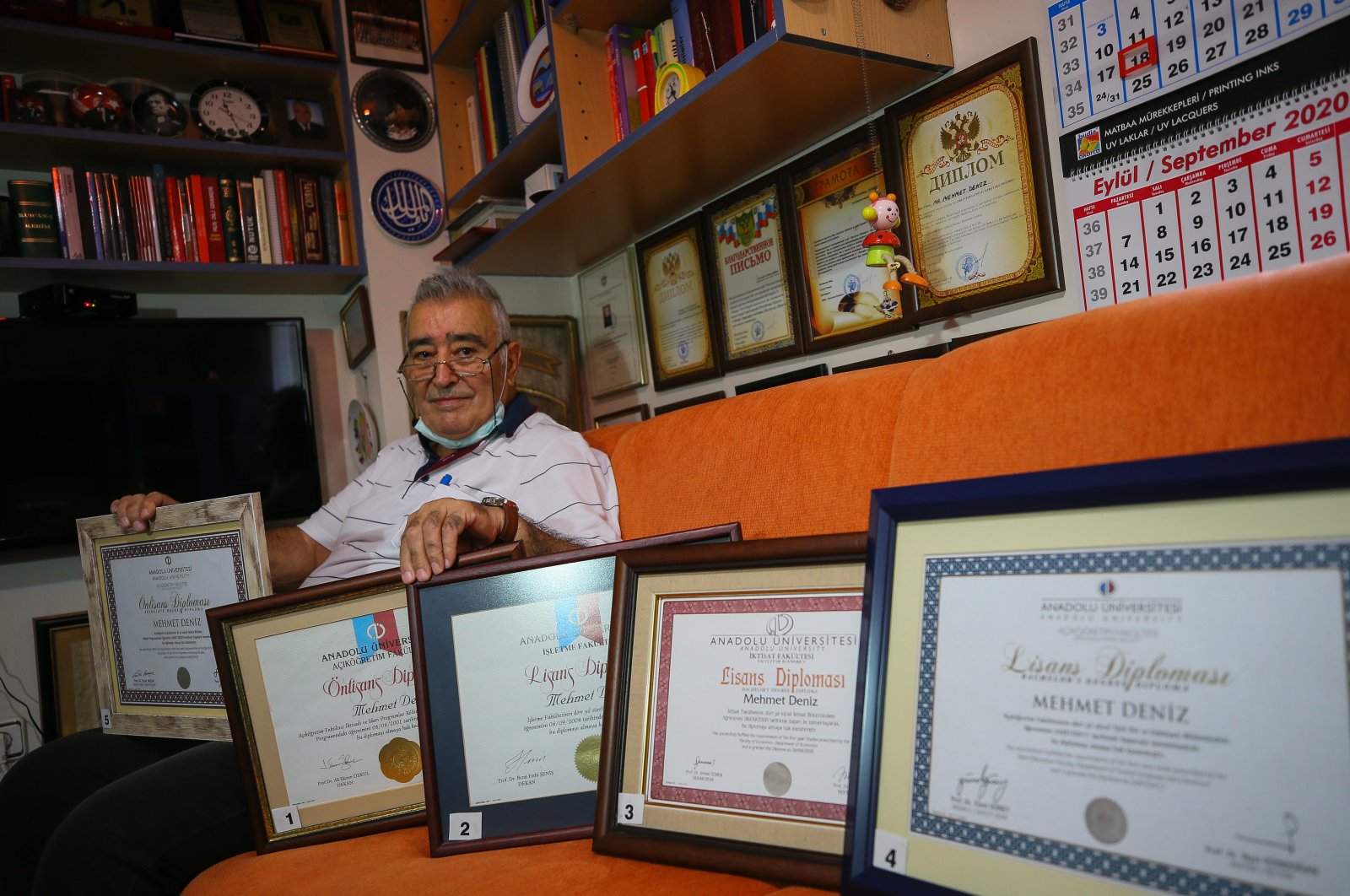 Mehmet Deniz shows his diplomas in his home, in Izmir, western Turkey, Aug. 19, 2020. (AA Photo)