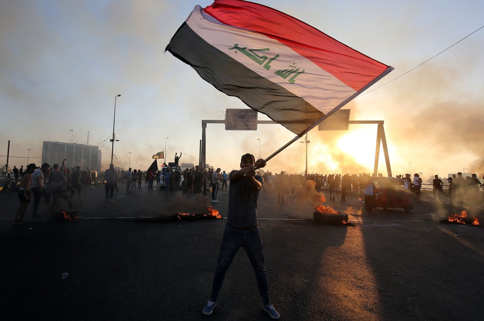 An Iraqi protester waves the national flag during a demonstration against state corruption, failing public services and unemployment in the Iraqi capital Baghdad, Oct. 5, 2019. (AFP Photo)