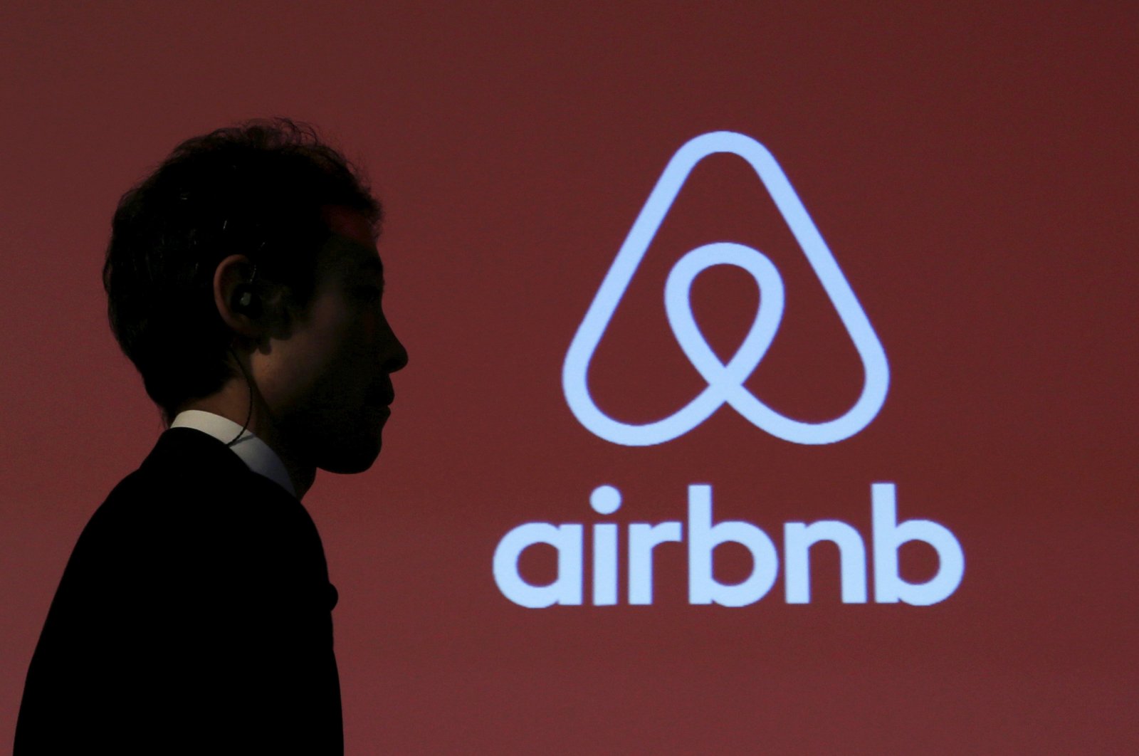 A man walks past a logo of Airbnb after a news conference in Tokyo, Japan, Nov. 26, 2015. (Reuters Photo)