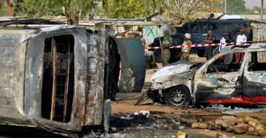 In this file photo, police officers stand guard following a suicide bomb explosion at a bus station in Kano, Nigeria, Feb. 24, 2015. (AP Photo)