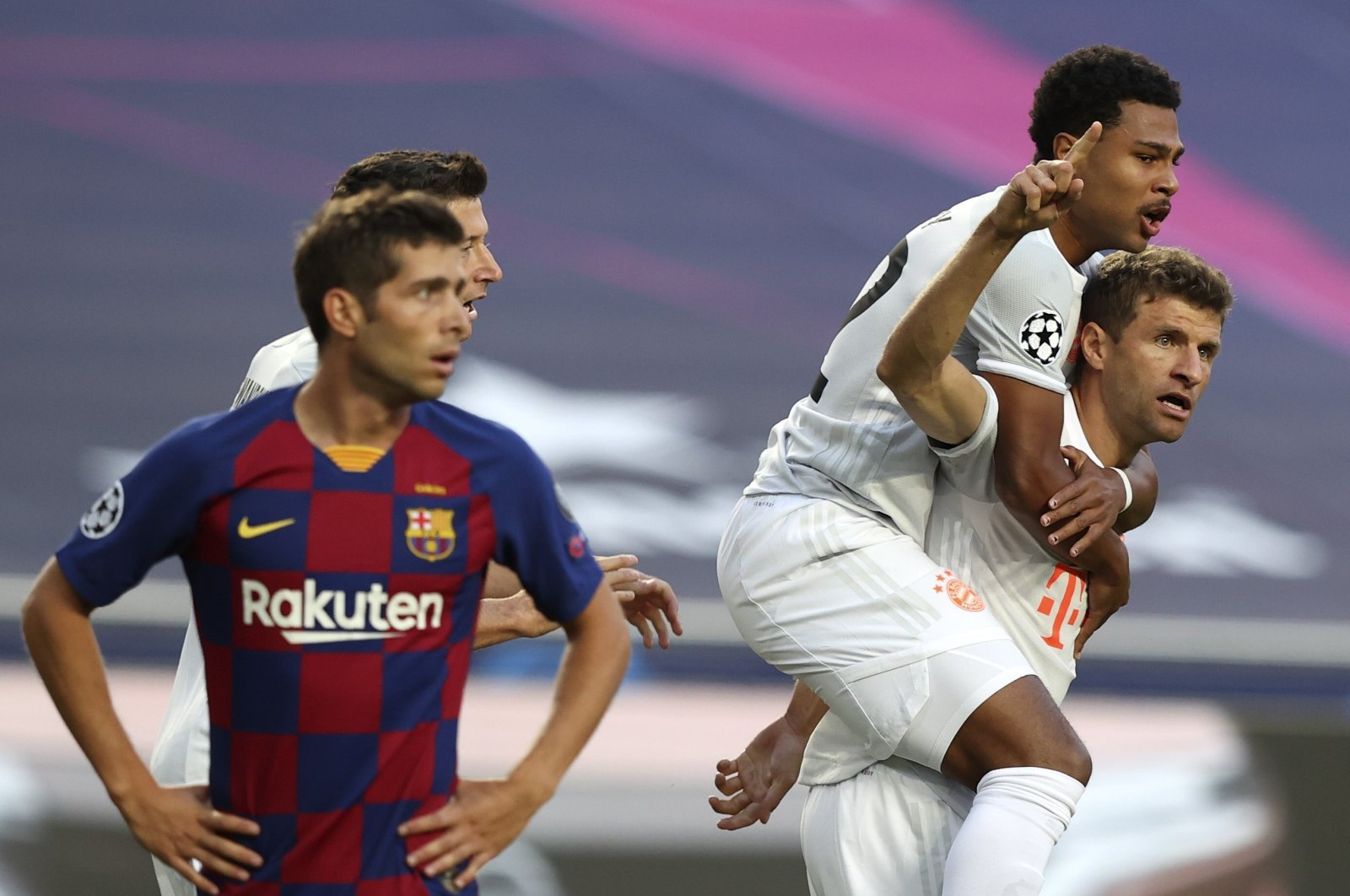 Bayern Munich's Thomas Muller (R) celebrates with Serge Gnabry after scoring a goal during a UEFA Champions League match against Barcelona in Lisbon, Portugal, Aug. 14, 2020. (AP Photo)