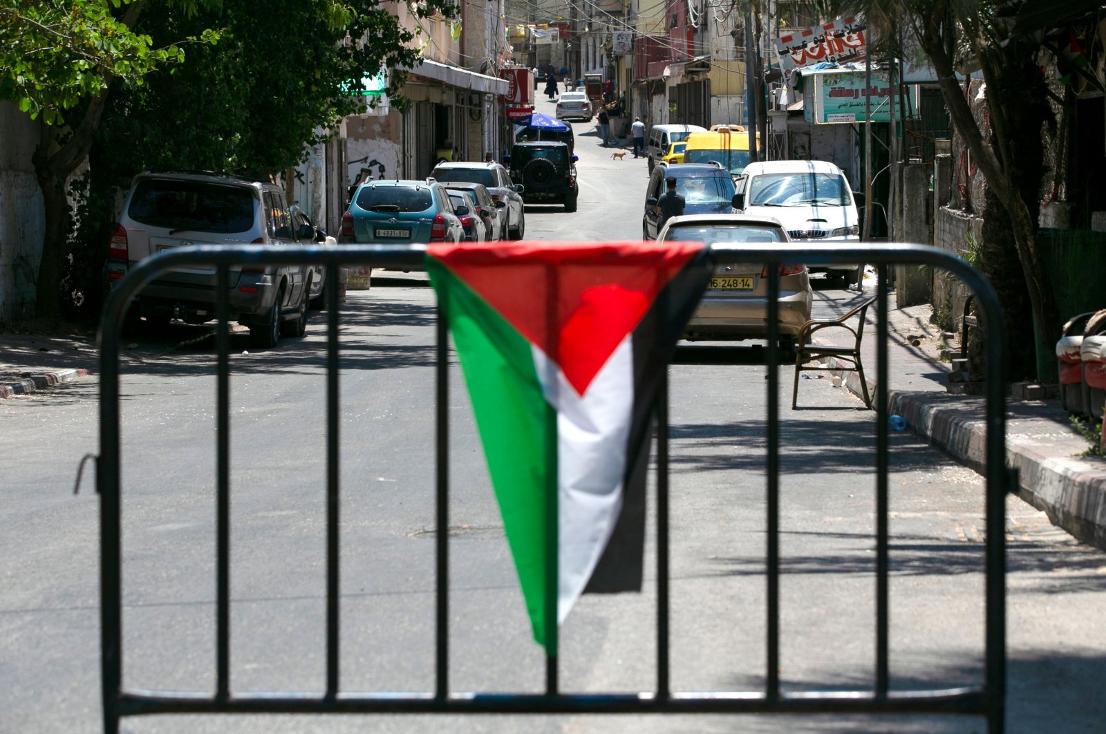 A Palestinian flag is draped over a metal barrier at a checkpoint at the entrance of Amari refugee camp near Ramallah, occupied West Bank, July 24, 2020. (AFP Photo)