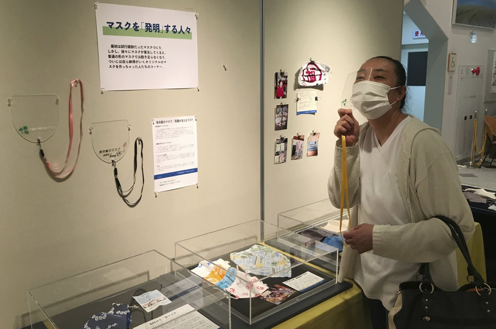 Shoko Maede, a nursery-school cook, looks at a display of masks at the Historical Museum of Urahoro in Urahoro, Hokkaido island, northern Japan, Aug. 14, 2020. (AP PHOTO)