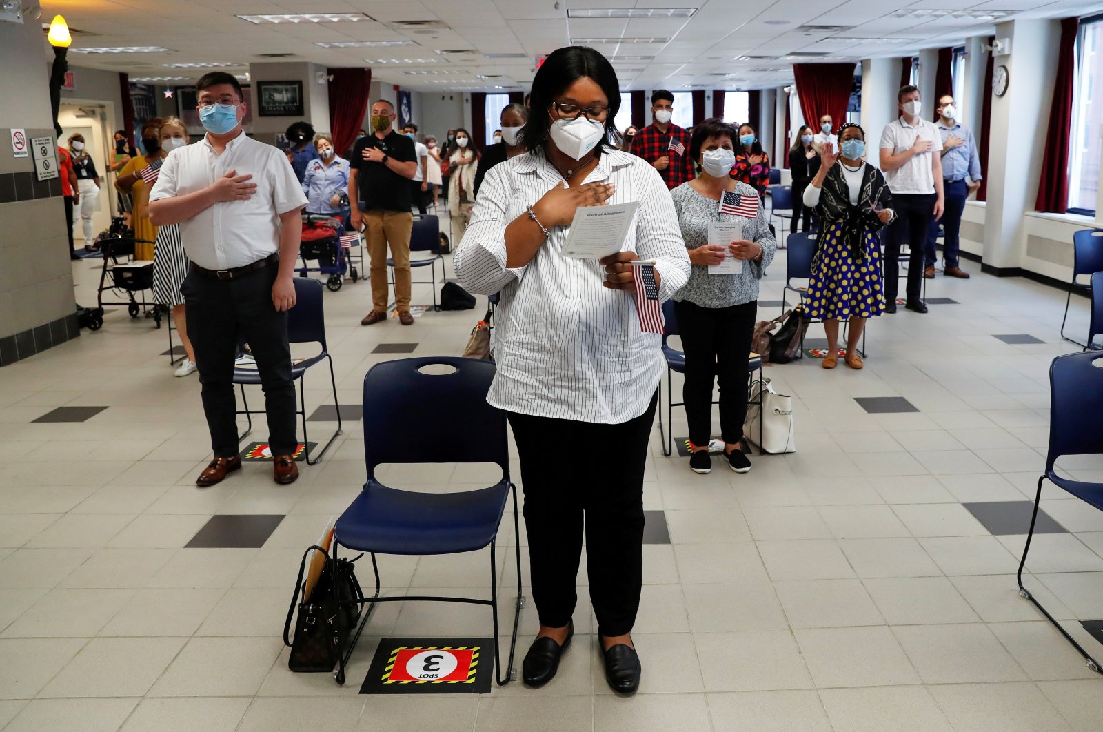 Ifeoma Eh, a citizen candidate from Nigeria, stands with others socially distanced and wearing protective face masks, as the outbreak of the coronavirus disease (COVID-19) continues, during a U.S. Citizenship and Immigration Services (USCIS) naturalization ceremony in New York, U.S., July 22, 2020. (Reuters Photo)