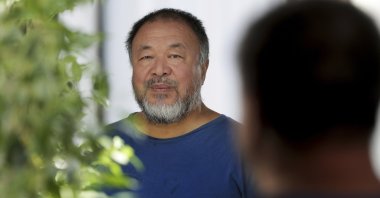 Chinese artist Ai Weiwei poses in front of a mirror for a photo after an interview with The Associated Press in Berlin, Germany, Monday, Aug. 12, 2019 (AP Photo)