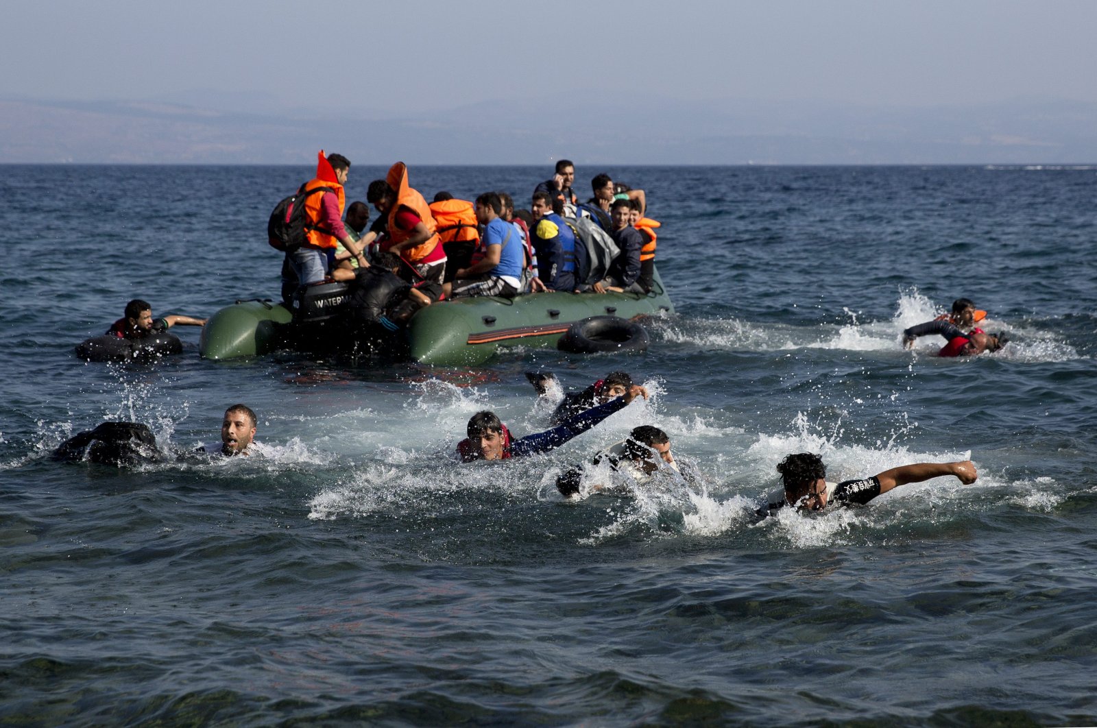 Migrants whose boat stalled at sea while crossing from Turkey to Greece swim toward the shore of the island of Lesbos, Greece, Sept. 20, 2015. (AP Photo)