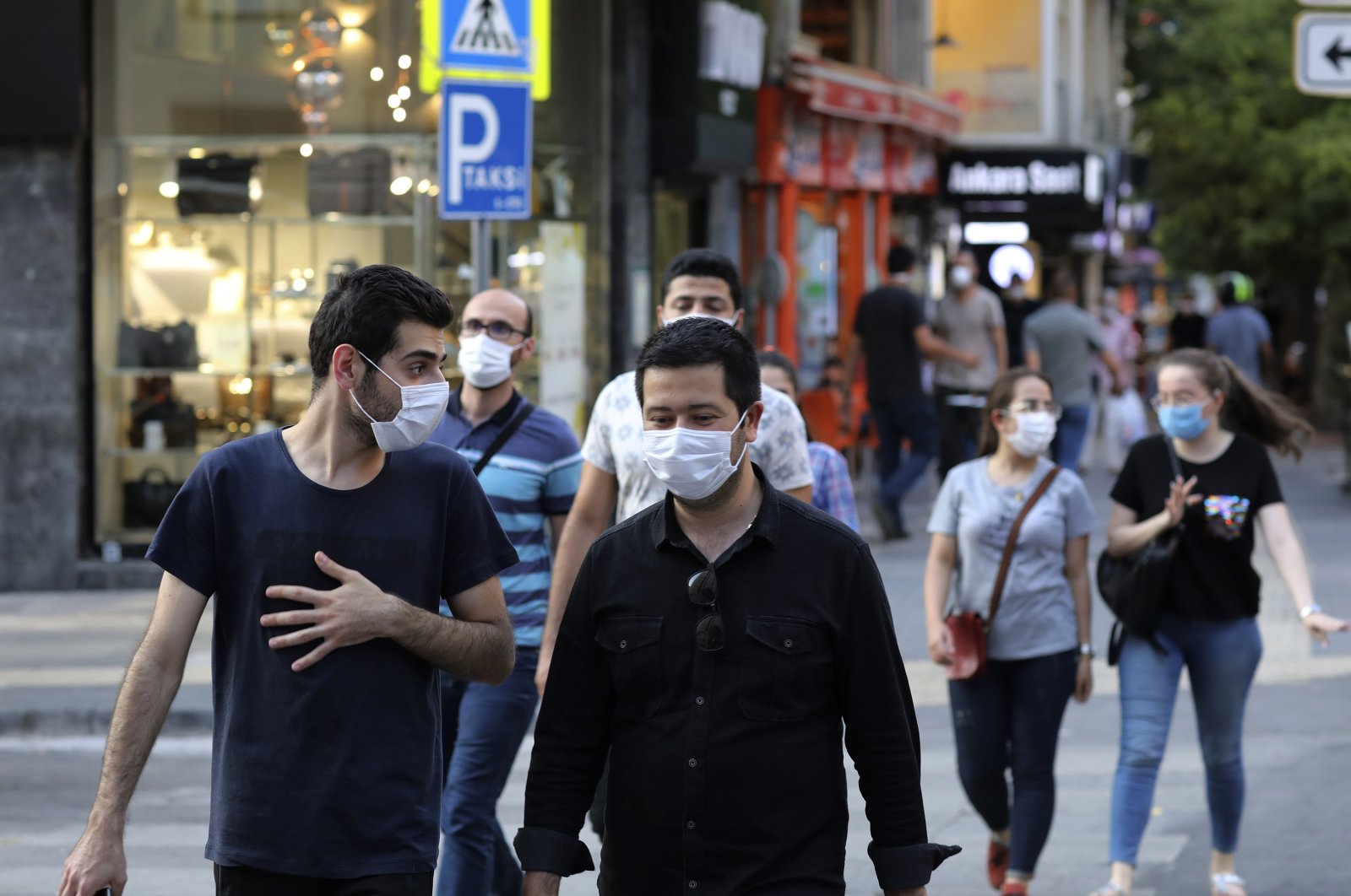People wearing face masks to protect against the spread of coronavirus, walk in Ankara, Turkey, Thursday, Aug. 6, 2020. Turkey's interior ministry announced new measures Wednesday to curb the spread of COVID-19 as daily confirmed cases peaked above 1,000. (AP Photo)