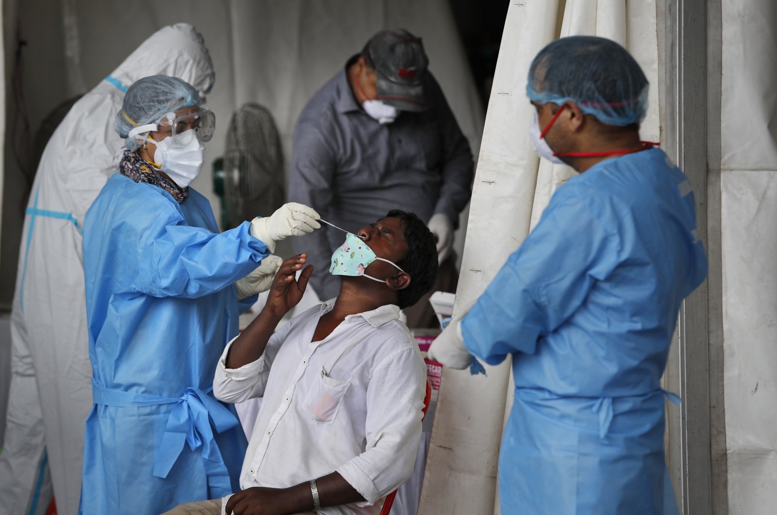 Health workers conduct COVID-19 antigen tests for migrant workers in New Delhi, India, Aug. 18, 2020. (AP Photo)