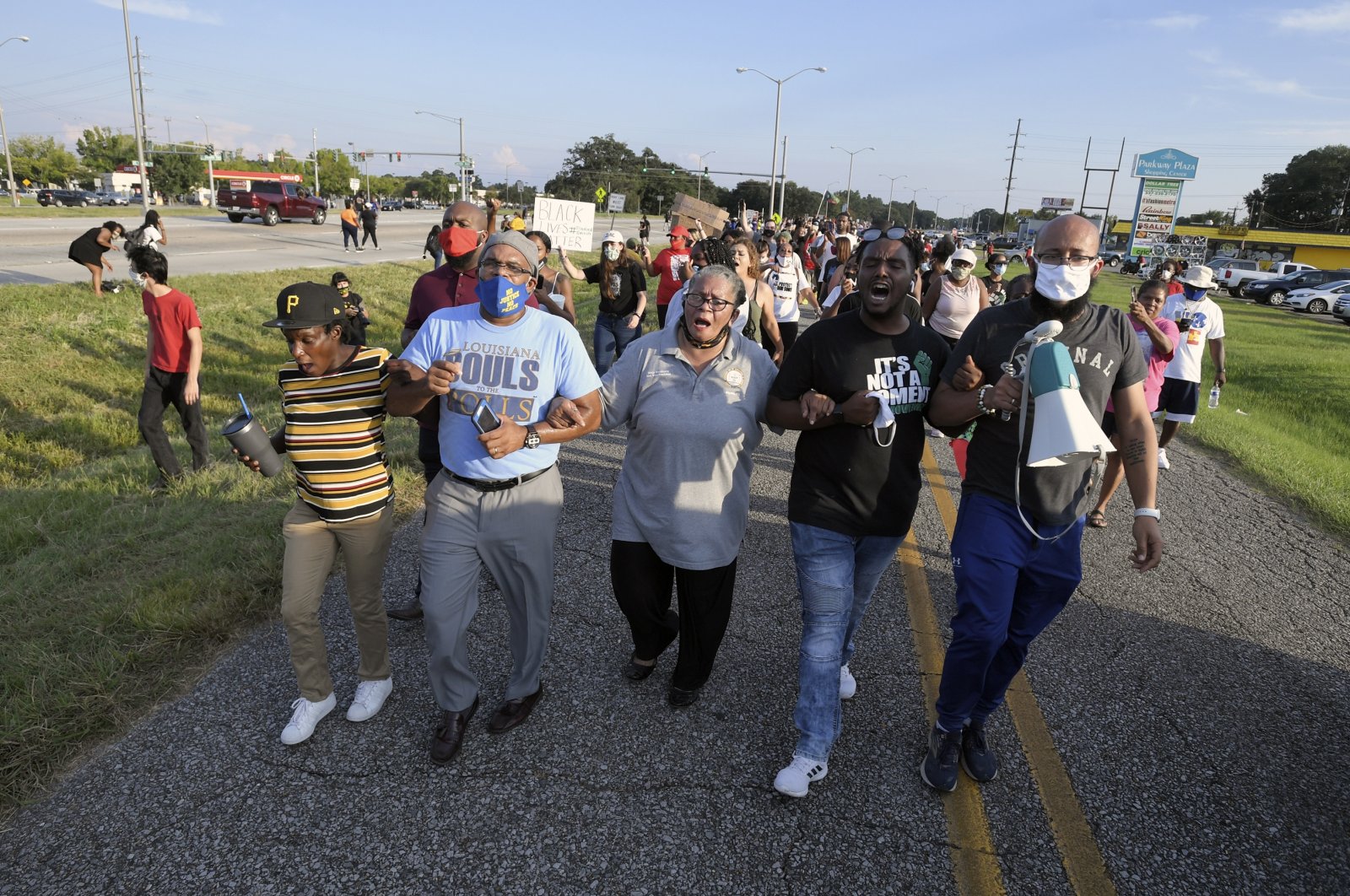 Marja Broussard, center, president of the Lafayette chapter of the NAACP, walks down Evangline Thruway with others demanding justice for Trayford Pellerin, Saturday, Aug. 22, 2020, in Lafayette, La. Pellerin was shot and killed by Lafayette police officers while armed with a knife the night before. (AP Photo)