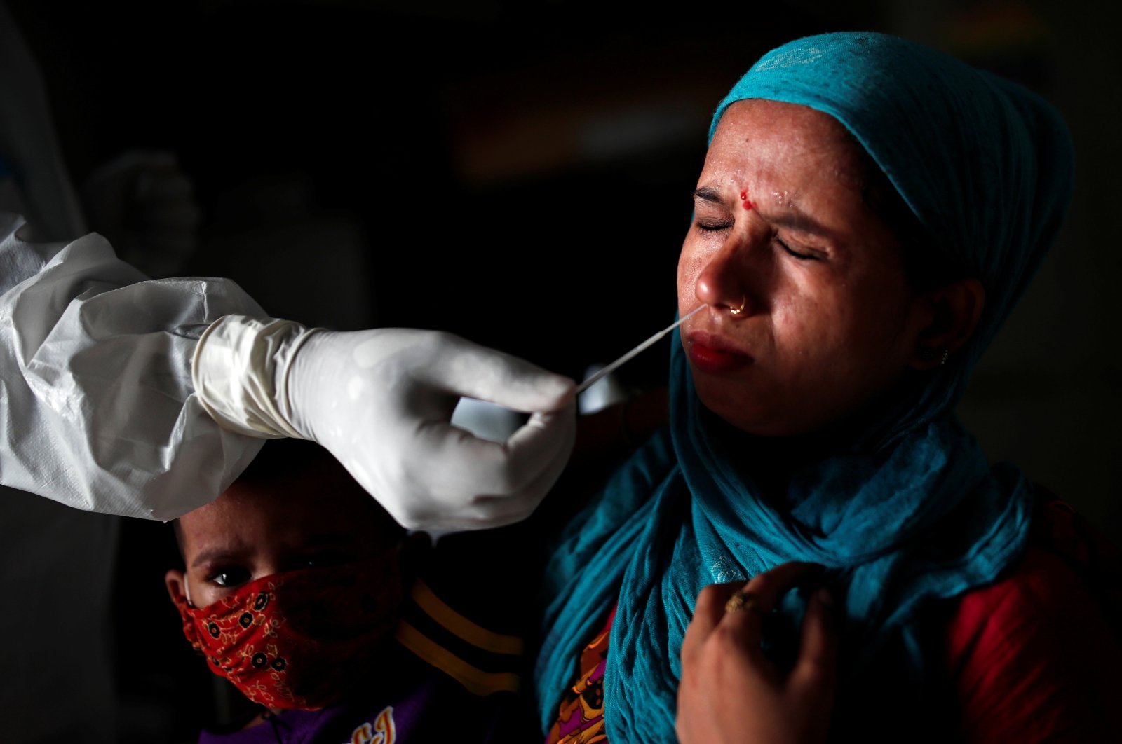 A medical health worker collects a sample from a woman using a swab, at a local health center to conduct tests for the coronavirus, in New Delhi, India, July 28, 2020. (Reuters Photo)