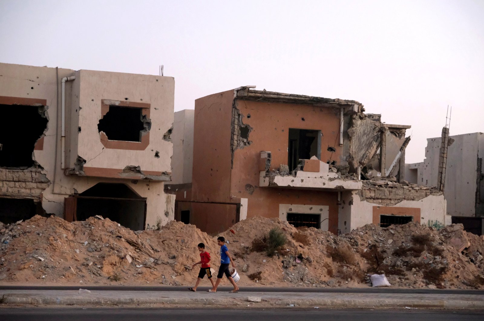 Boys walk past houses that were destroyed in past fighting with Daesh militants in Sirte, Libya, Aug. 17, 2020. (REUTERS Photo)