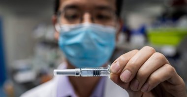 An engineer shows an experimental vaccine for COVID-19 that was tested at the Quality Control Laboratory at the Sinovac Biotech facilities, Beijing. Apr. 29, 2020. (AFP Photo)