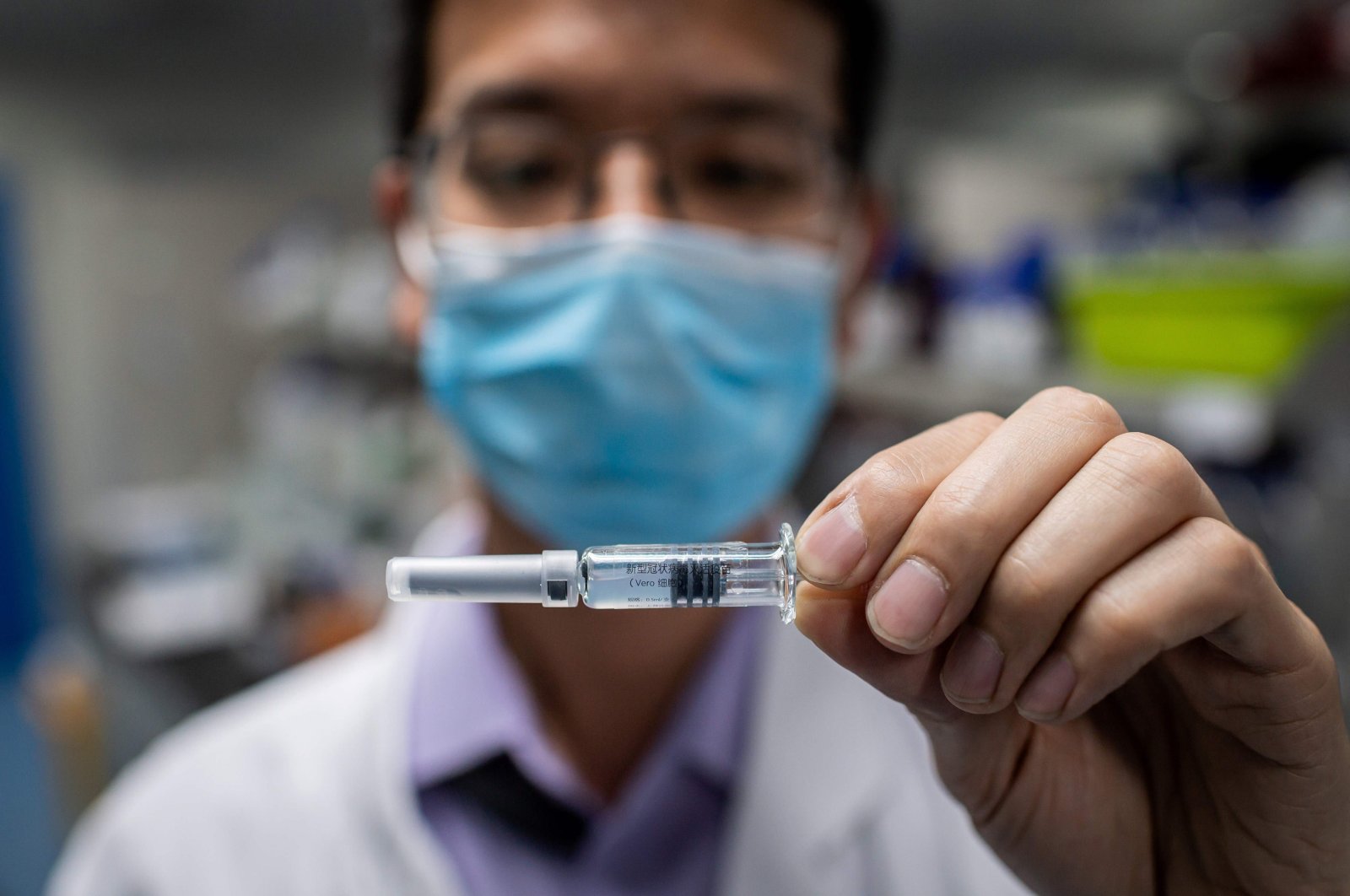 An engineer shows an experimental vaccine for COVID-19 that was tested at the Quality Control Laboratory at the Sinovac Biotech facilities, Beijing. Apr. 29, 2020. (AFP Photo)