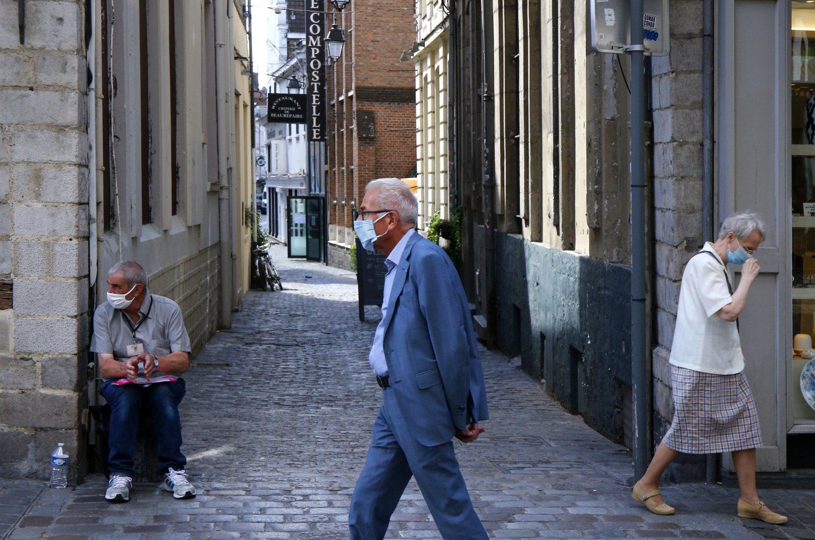 People wearing protective face masks as a precaution against the coronavirus are seen in a street of Lille, northern France, Aug. 21, 2020. (AP Photo)