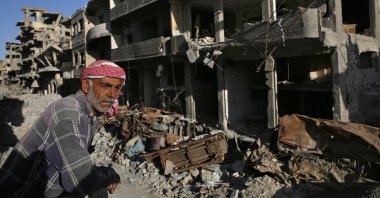 A Syrian man stands between buildings destroyed during the fighting against Daesh militants in Raqqa, April 5, 2018. (AP Photo)