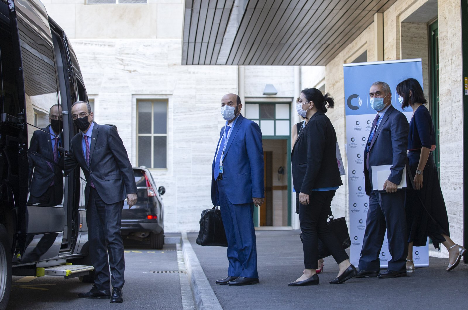 Syrian Constitutional Committee Co-Chair Hadi al-Bahra (L) leaves following the announcement of the suspension of the conference due to cases of COVID-19, at the European headquarters of the United Nations in Geneva, Switzerland, Aug. 24, 2020. (AP Photo)