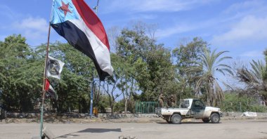 Fighters with Yemen's Southern Transitional Council (STC) drive a vehicle past a separatist flag (the old flag of South Yemen) as they deploy in the southern city of Aden, April 26, 2020. (AFP Photo)