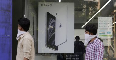 People walk past an image of an iPhone displayed at an Apple store in Ahmedabad, India, Saturday, Aug. 1, 2020. (AP Photo)
