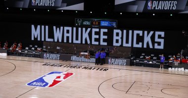Referees huddle on an empty court at game time of a scheduled NBA playoff game between the Milwaukee Bucks and the Orlando Magic in Lake Buena Vista, Florida, U.S., Aug. 26, 2020. (AP Photo)