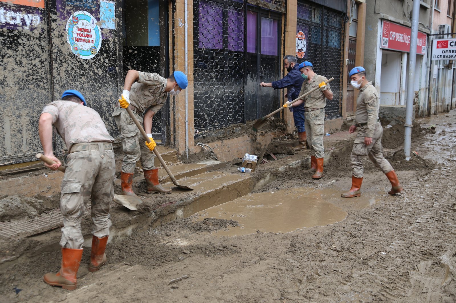 Soldiers help clean the mud in front of a shop in Dereli district, in Giresun, northern Turkey, Aug. 27, 2020. (AA Photo)