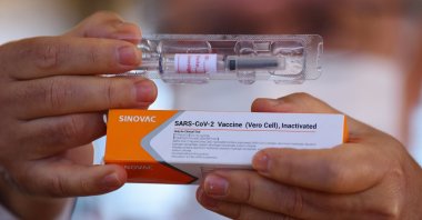 Professor Gustavo Romero, who coordinates research on the coronavirus vaccine in Brazil, shows a dose of Sinovac's coronavirus vaccine in a phase three trial at the University Hospital of Brasilia, in Brasilia, Brazil, Aug. 5, 2020. (EPA Photo)