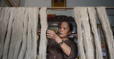 Vietnamese weaver, Phan Thi Thuan checking lotus "silk" yarns at her workshop in Hanoi on Aug. 26, 2020. (Photo by Nhac NGUYEN / AFP)