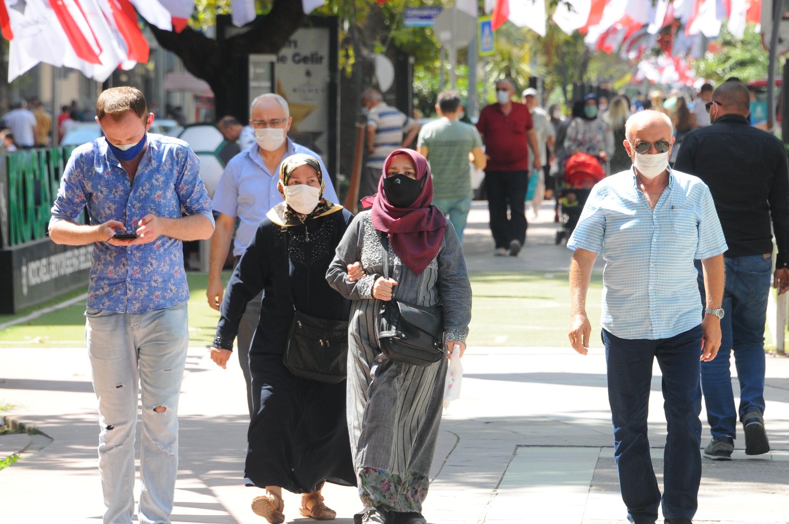 People wearing protective masks walk on a street in Kocaeli, northwestern Turkey, Aug. 26, 2020. (DHA Photo) 