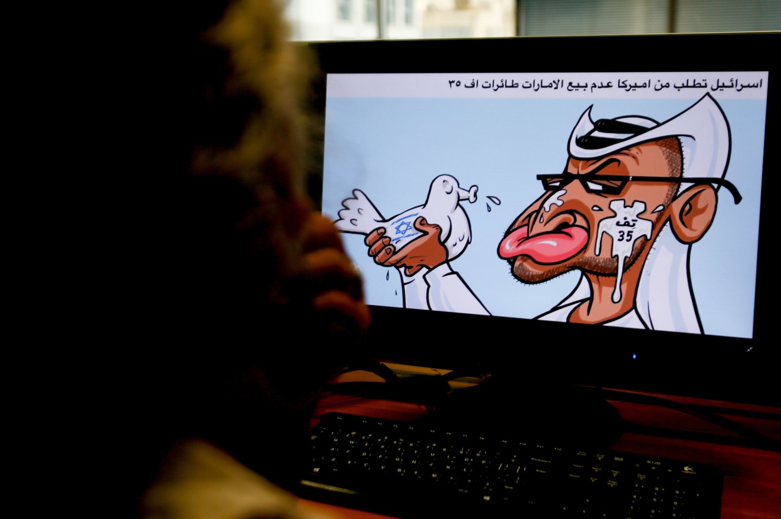 A woman looks at a caricature by Jordanian cartoonist Emad Hajjaj depicting the leader of the United Arab Emirates (UAE), Sheikh Mohammed bin Zayed al-Nahyan, holding a dove with Israel's flag on it spitting in his face with Arabic writing referring to Israel's opposition to the sale of U.S. F-35 aircraft to the UAE, on Aug. 27, 2020. (AFP Photo)