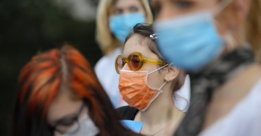 Protesters wear face masks outside the presidential palace in Bucharest, Romania, June 18, 2020, during a rally against a law banning the teaching of gender studies. (AP Photo)