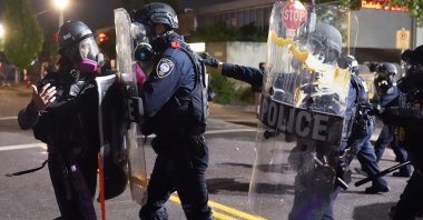 Federal officers use riot shields to push a protester while dispersing a crowd of about 150 people from in front of the Immigration and Customs Enforcement (ICE) detention facility in Portland, Oregon, U.S., Aug. 20, 2020. (AFP/Getty Images)