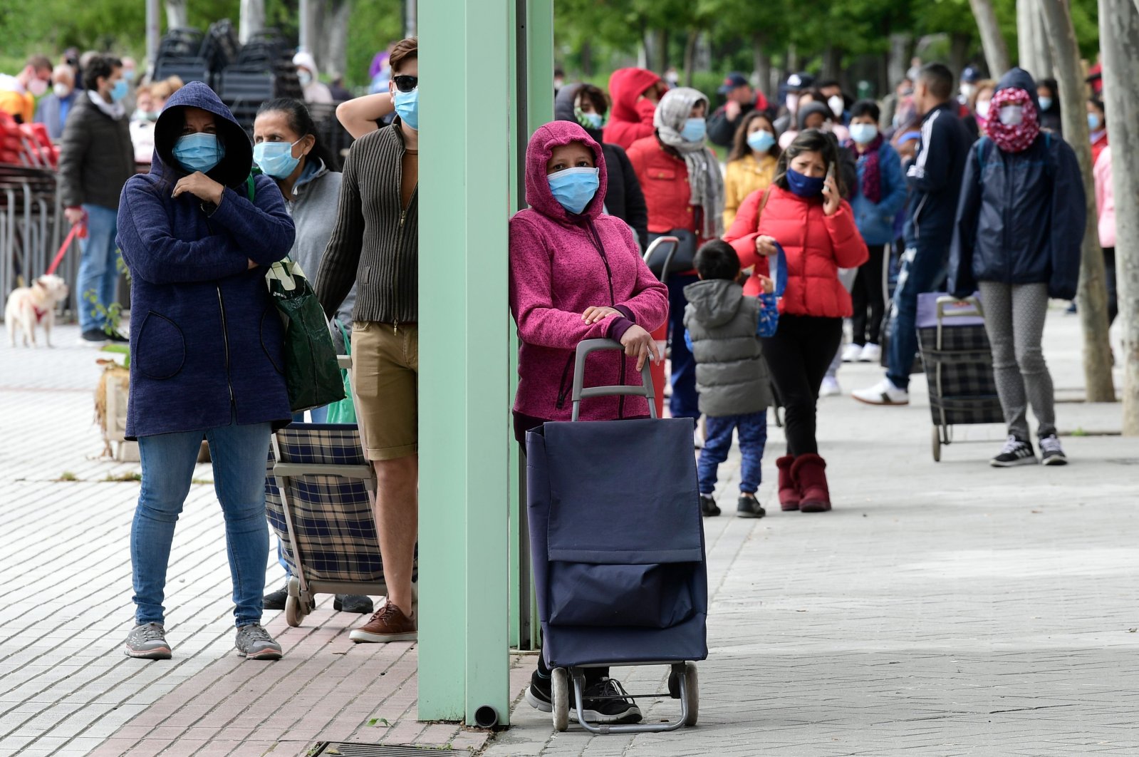 People queue to get a free food ration from the Aluche Neighborhood Association (AVA)'s food bank in Madrid, Spain, May 16, 2020. (AFP Photo)