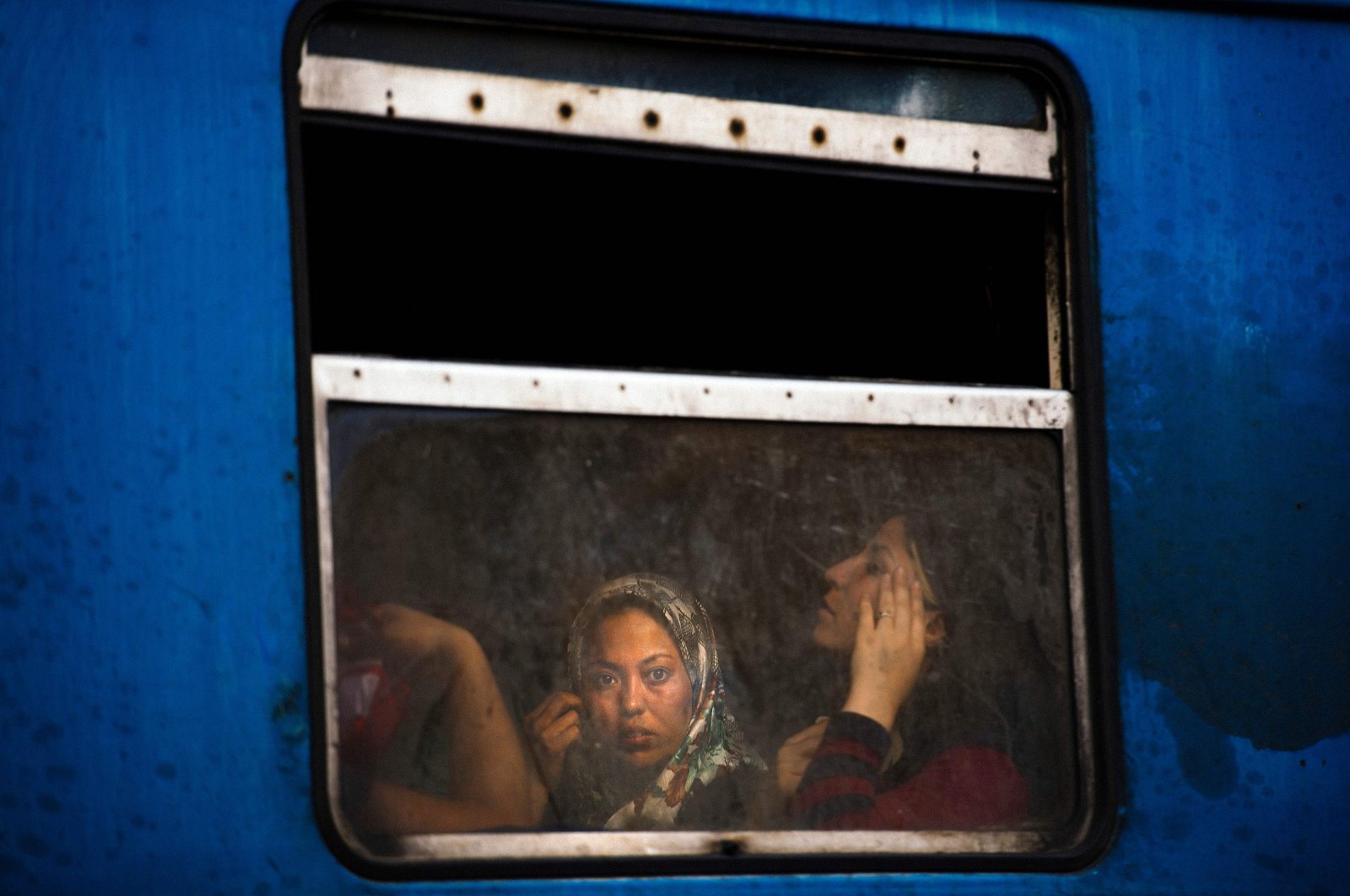 A migrant woman looks out the window of a train heading to the border with Serbia at the train station in Gevgelija, on the Macedonian-Greek border, Aug. 4, 2015. (AFP Photo)