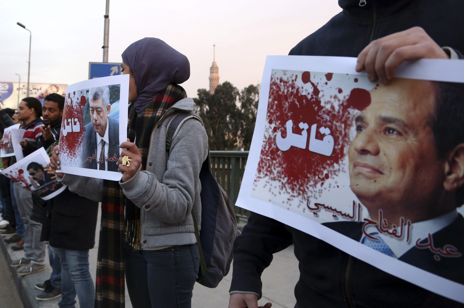 Protesters hold posters of Egyptian Interior Minister Mohamed Ibrahim (L) and President Abdel-Fattah el-Sissi with the word "Killer" on them during a silent protest on a bridge in Cairo, Egypt, Feb. 14, 2015. (Reuters Photo)