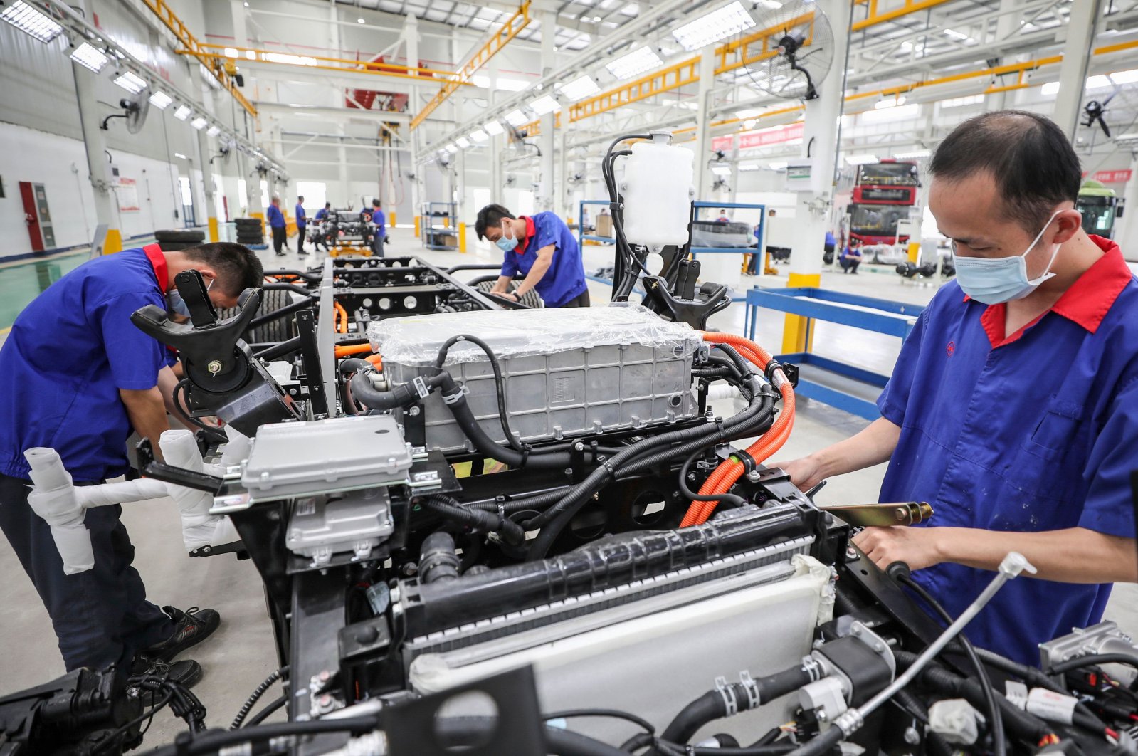 Employees working on a new energy vehicle (NEV) assembly line at a BYD Auto factory in Huaian in China's eastern Jiangsu province, July 6, 2020. (AFP Photo)