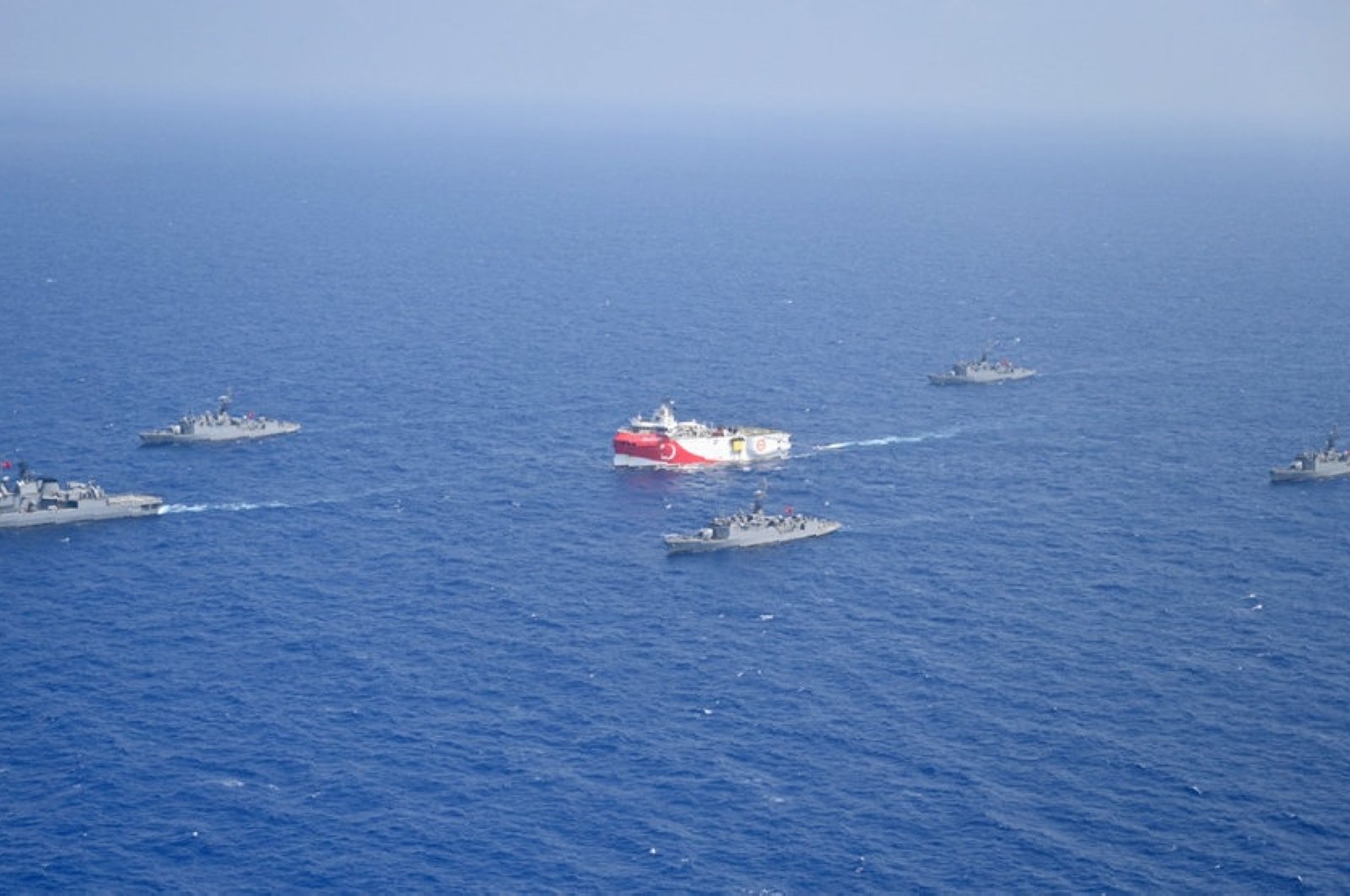Turkey's research vessel, Oruç Reis, in red and white, is surrounded by Turkish navy vessels as it was heading in the west of Antalya on the eastern Mediterranean, Turkey, Aug 10, 2020. (AP)