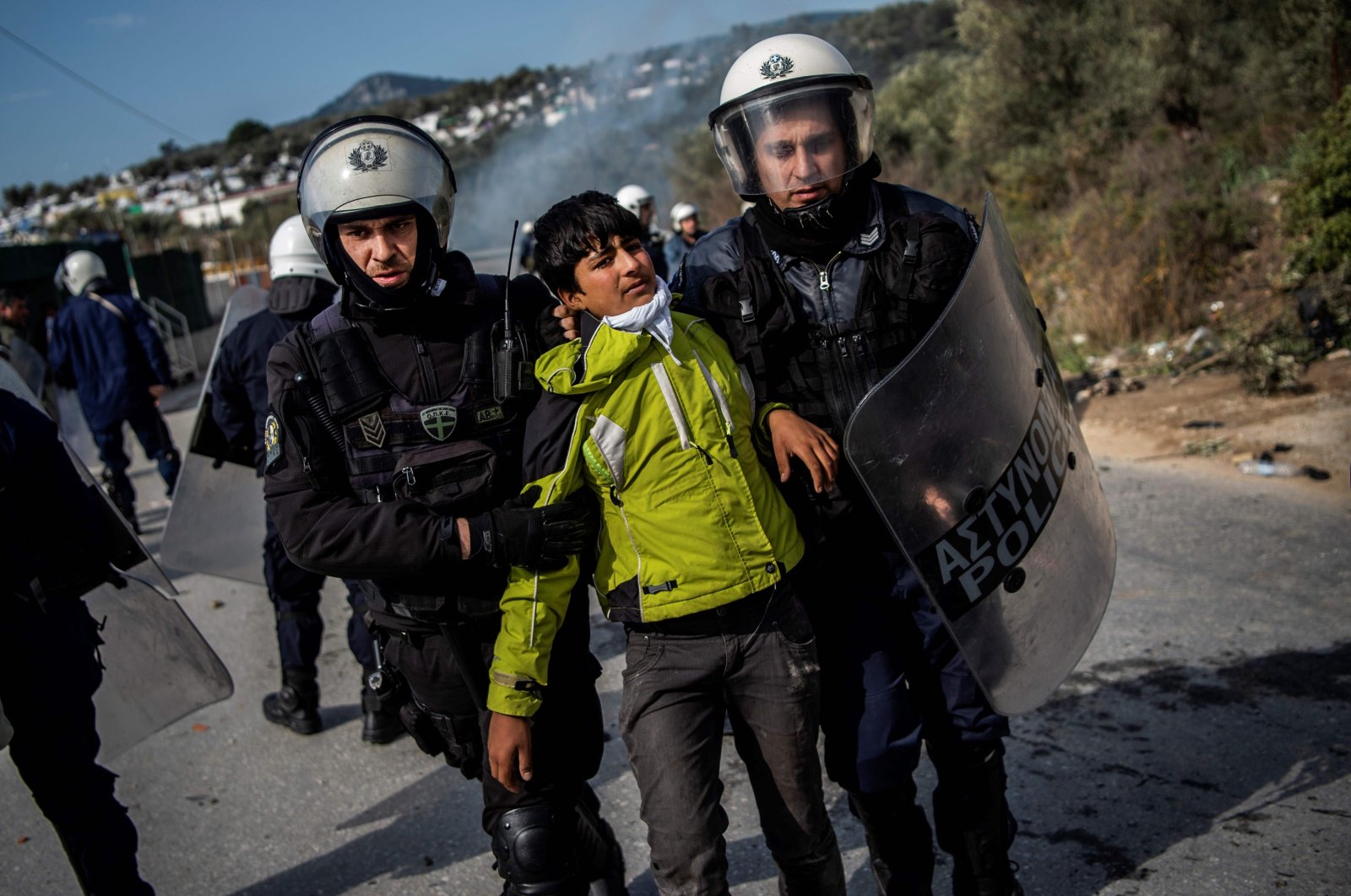 Riot police detain a migrant during clashes near the Moria camp for refugees and migrants, on the island of Lesbos, on March 2, 2020. (AFP Photo)