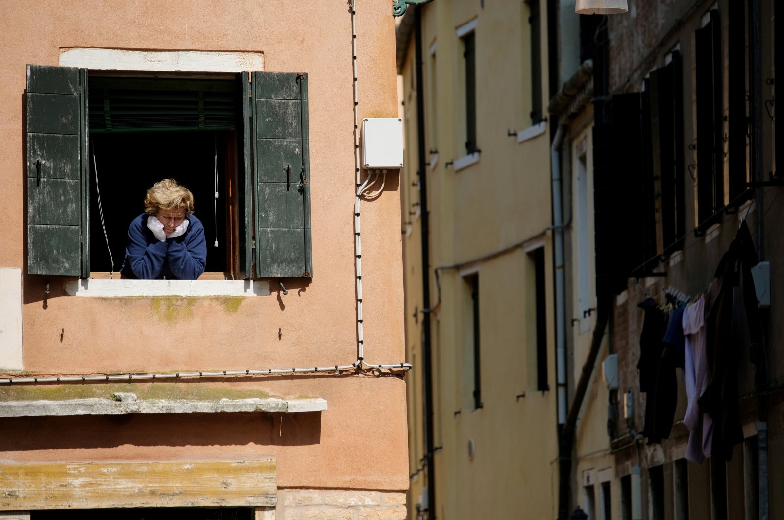 A woman looks out of an apartment window as Italians remain under lockdown to prevent the spread of the coronavirus pandemic, Venice, Italy, April 4, 2020. (Reuters Photo)
