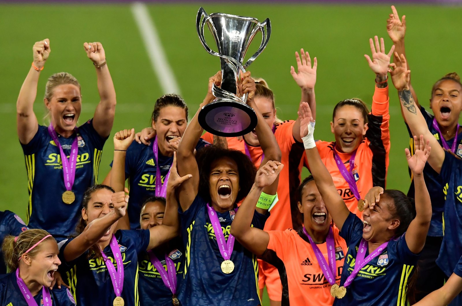 Lyon's Wendie Renard raises the trophy as she celebrates with teammates after winning the UEFA Women's Champions League final football match against Wolfsburg in San Sebastian, Spain, Aug. 30, 2020. (AFP Photo)