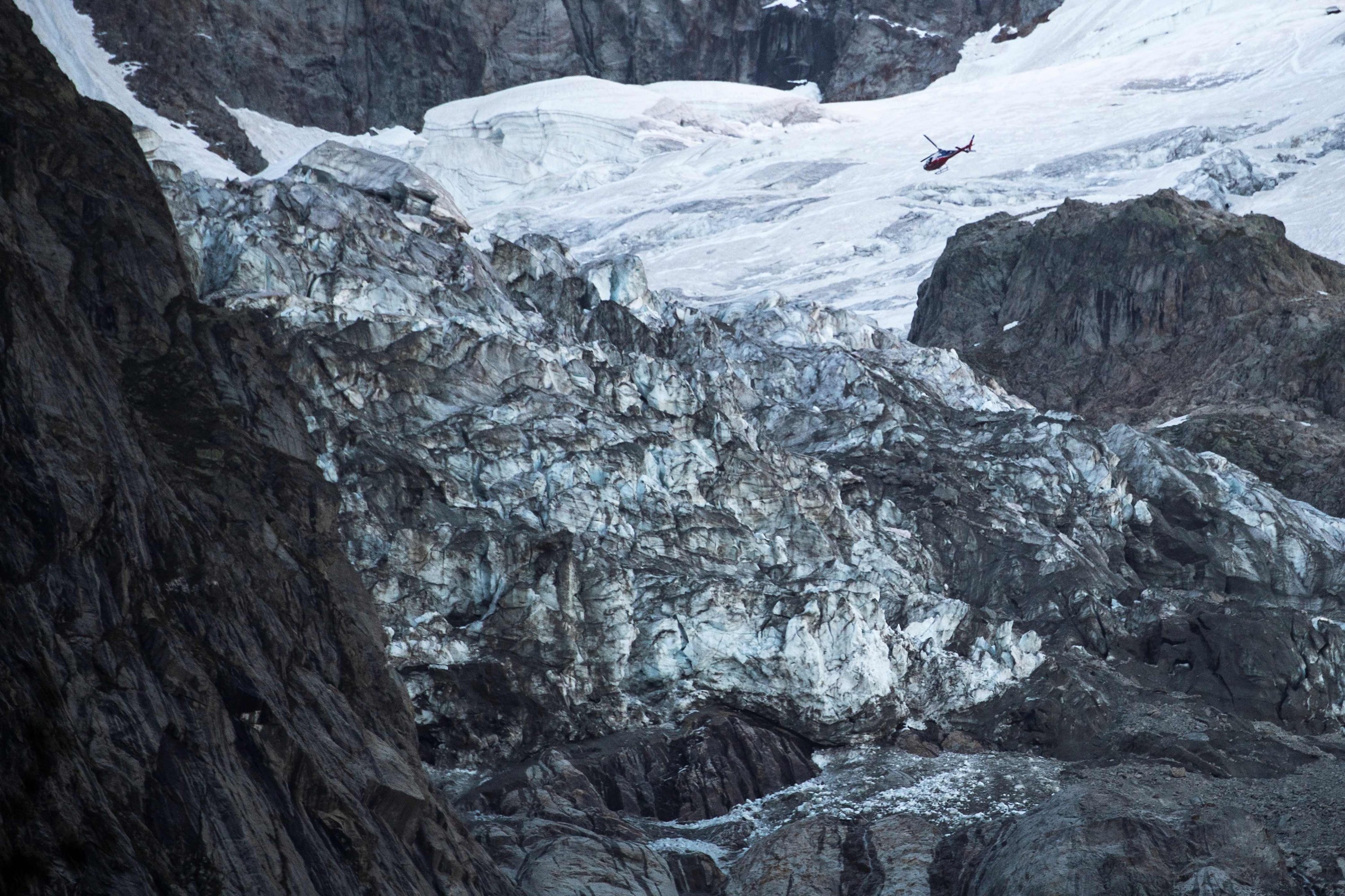 A helicopter flies above the Planpincieux glacier near the village of La Palud, in Courmayeur, Val Ferret, northwestern Italy, on Aug. 6, 2020. (AFP Photo)