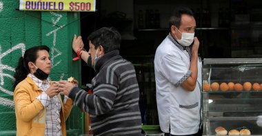 People with face masks converse outside a cafeteria during the government-mandated quarantine to lower the rates of contagion from the coronavirus outbreak, in Bogota, Colombia, July 27, 2020. (Reuters Photo)