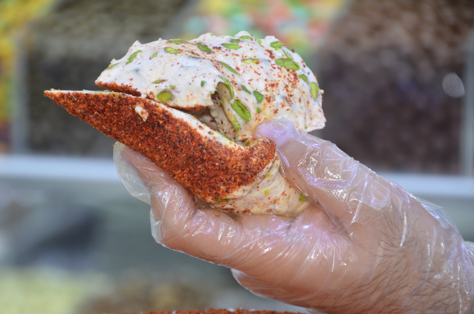 A man extends a sweet and spicy creation produced by confectioner Ökkeş Nagaş in Kahramanmaraş, southern Turkey, Aug. 25, 2020. (AA Photo)