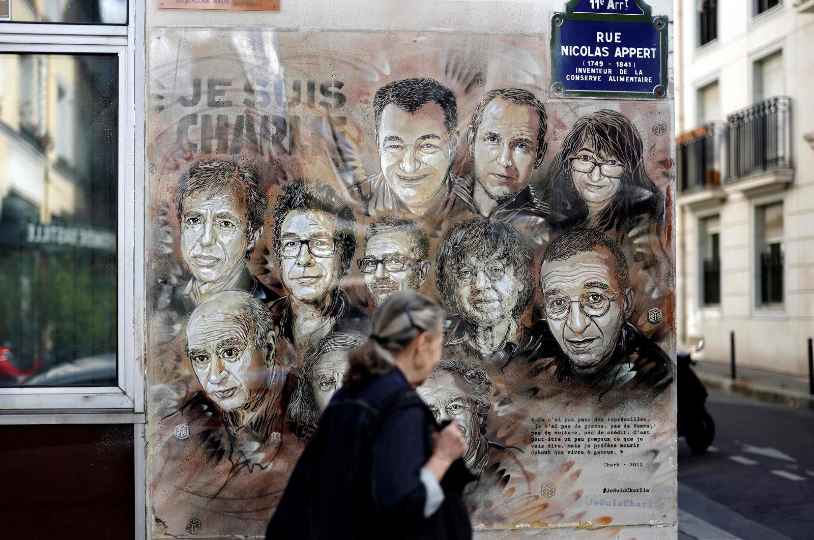 A woman walks past a painting by a French street artist in Paris, France, Aug. 31, 2020. (AFP Photo)