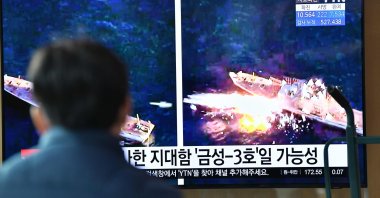 A man watches a television news broadcast showing file footage of a North Korean missile test, at a railway station in Seoul, April 14, 2020.