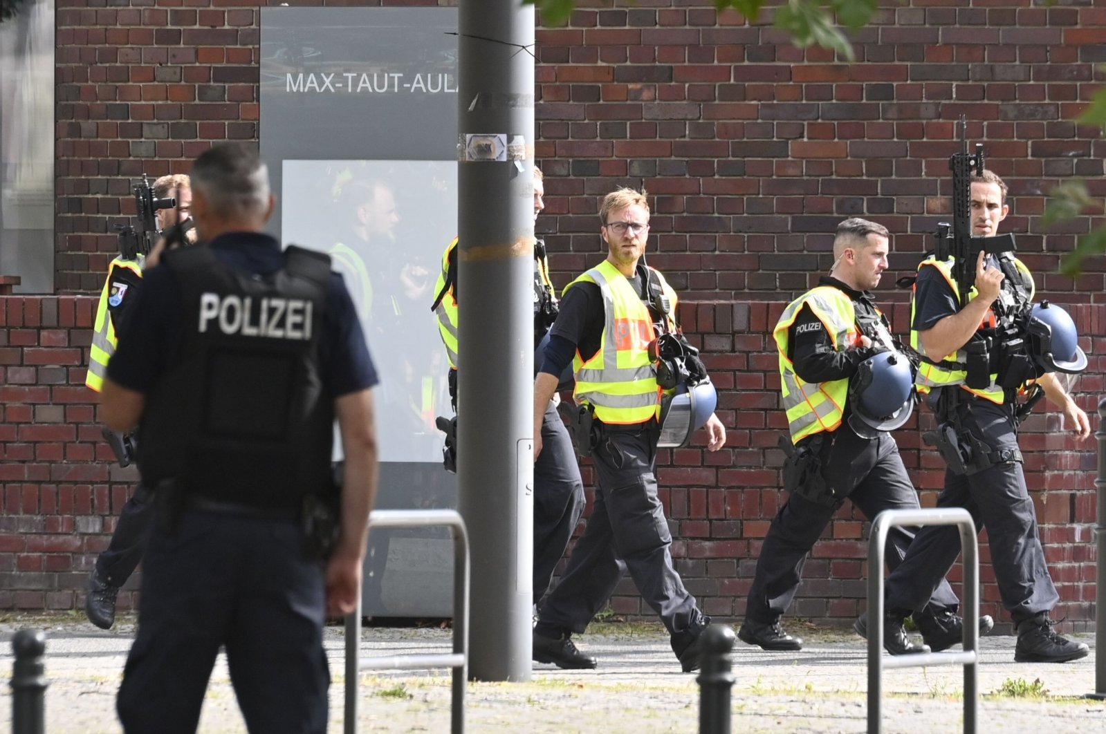 German armed policemen walk past a school in Berlin's Rummelsburg district, Germany, Aug. 28, 2020. (AFP Photo)