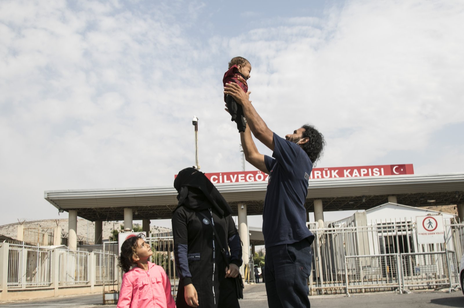 Khaled Misaytif holds his boy Muhammad as the family arrives at the Cilvegözü border crossing in Hatay, southern Turkey, Sept. 1, 2020. (AA Photo)