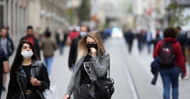 Two women walk on Istiklal Avenue wearing masks to protect against COVID-19, in Istanbul, Turkey, May 8, 2020. (AA Photo)
